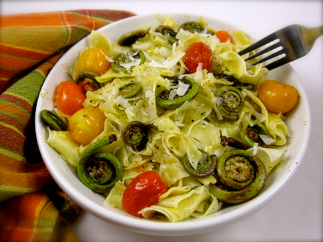 a bowl of pasta with red and yellow cherry tomatoes and fiddleheads referencing FoodWooWoo - Spiritual Nutrition 