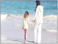 A woman and girl on a beach holding hands, referencing finding love